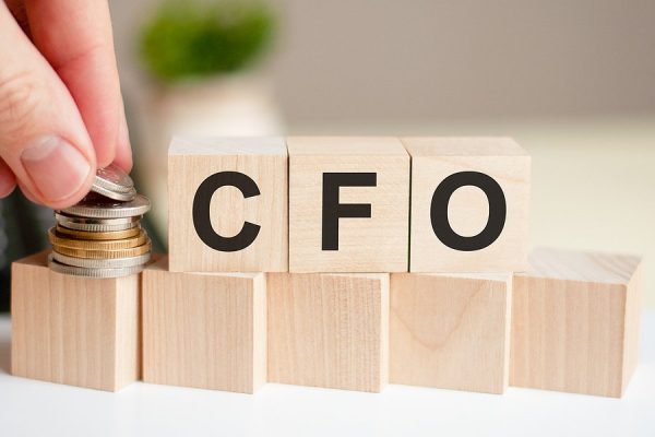 The Word Cfo Written On Wood Cubes. A Man’s Hand Places The Coin The Word Cfo Written On Wood Cubes. A Man's Hand Places The Coin